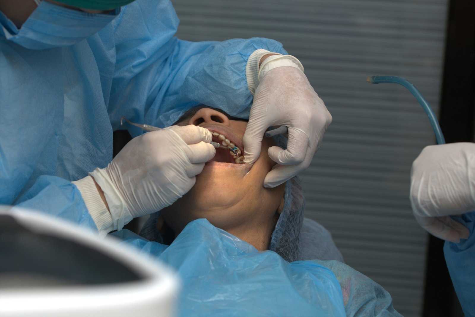 Dentist examining a patient's teeth during a dental consultation for tooth sensitivity